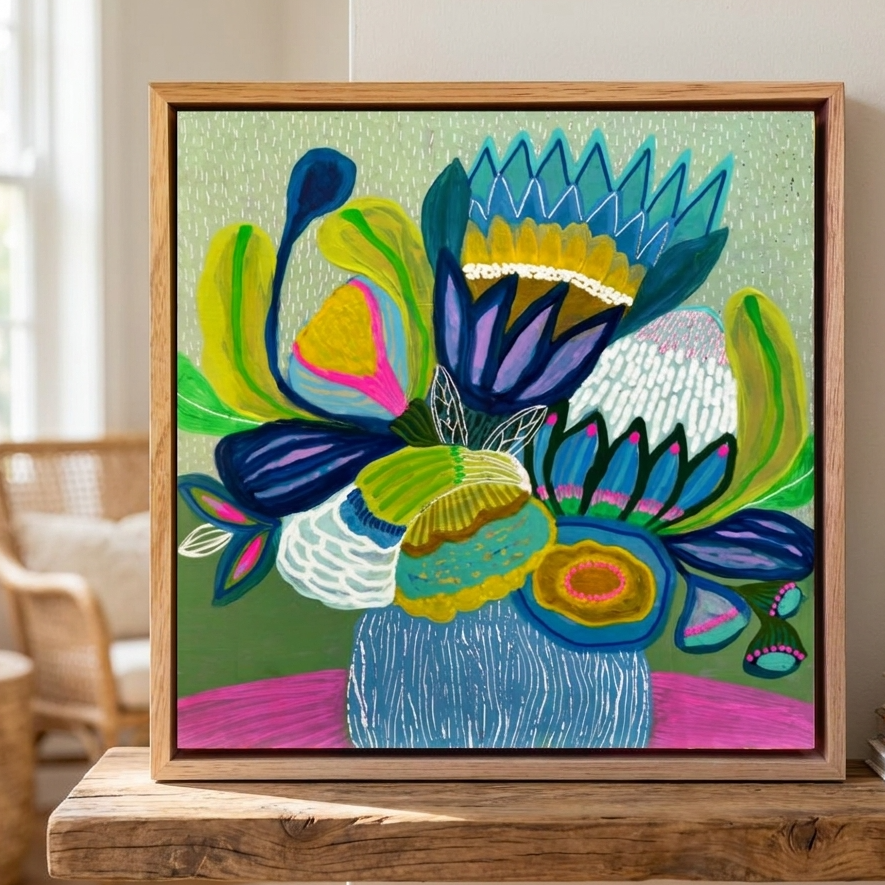 Colorful abstract floral painting in a wooden frame on a table.