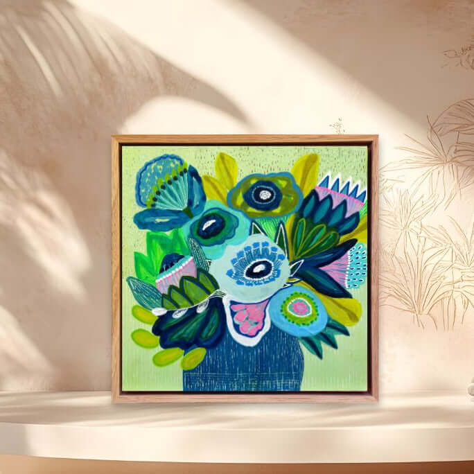 Framed colorful abstract art piece on a shelf with a decorative background