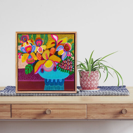 Colorful floral painting on a wooden shelf with a plant