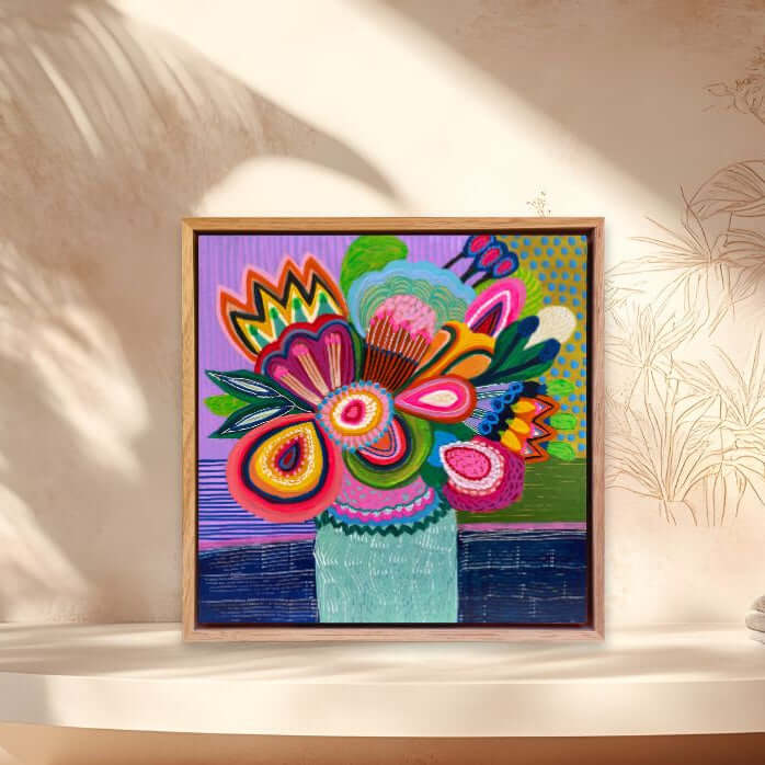 Colorful abstract floral painting by Kirsten Katz in a wooden frame on a beige wall