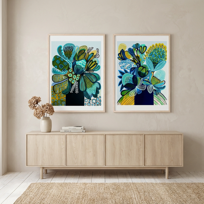 Two modern abstract floral artworks on a wall above a wooden sideboard.