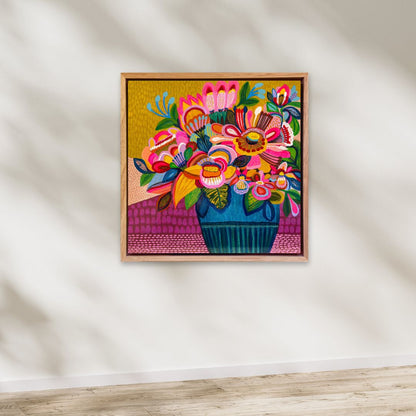 Colorful floral artwork in a wooden frame on a white wall.