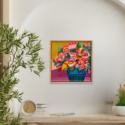Colorful floral artwork on a wall with a plant and books below