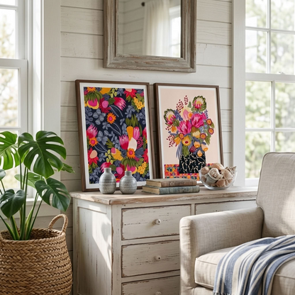 Kirsten Katz protea print pair, a bouquet of pink proteas on a warm ground beside bush flowers on deep navy