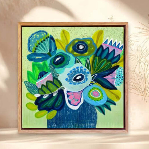 Framed colorful abstract art piece on a shelf with a decorative background