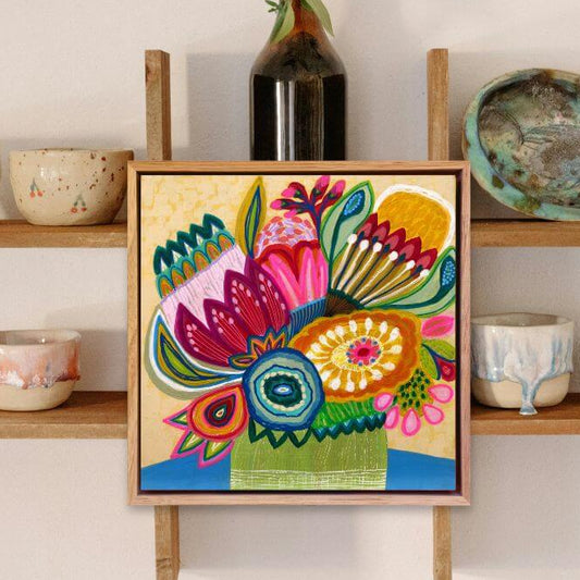 Original modern painting by Kirsten Katz   on a wooden easel against a white wall with shelves displaying various ceramic items.