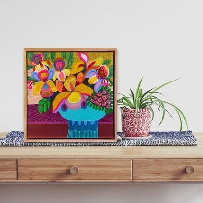 Colorful floral painting on a wooden shelf with a plant