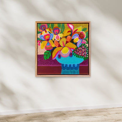 Colorful floral artwork in a wooden frame on a white wall.