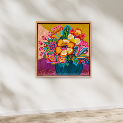Colorful floral artwork in a wooden frame on a white wall.