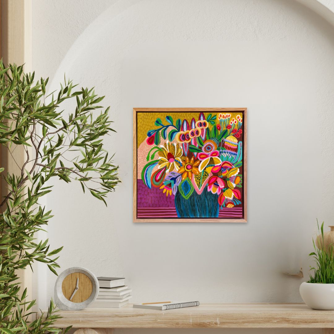 Colorful abstract painting on a wall with a plant and books below.