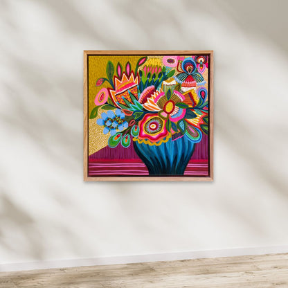 Colorful floral artwork in a wooden frame on a white wall.
